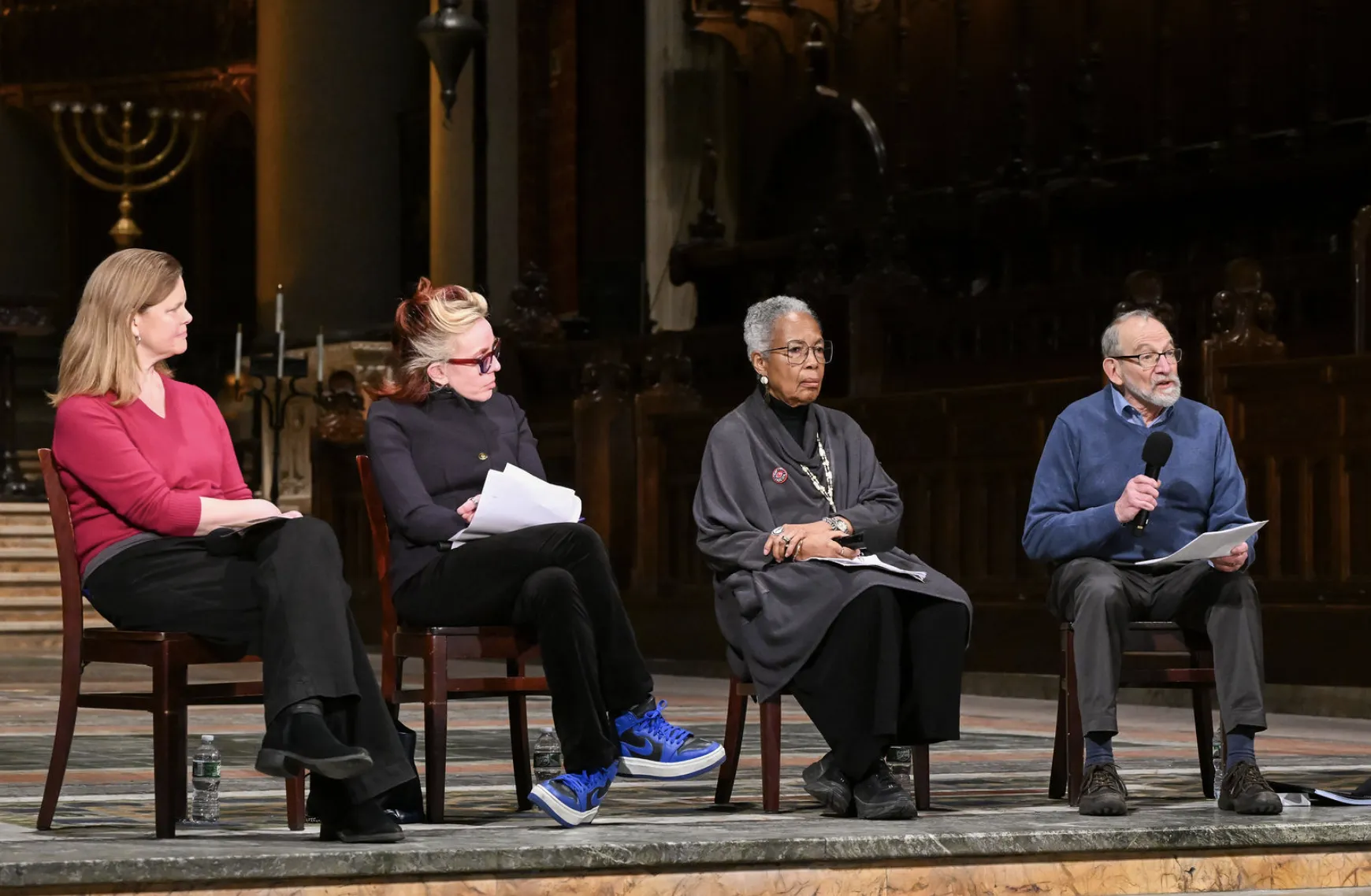 Photo of all four panelists as one shares his remarks